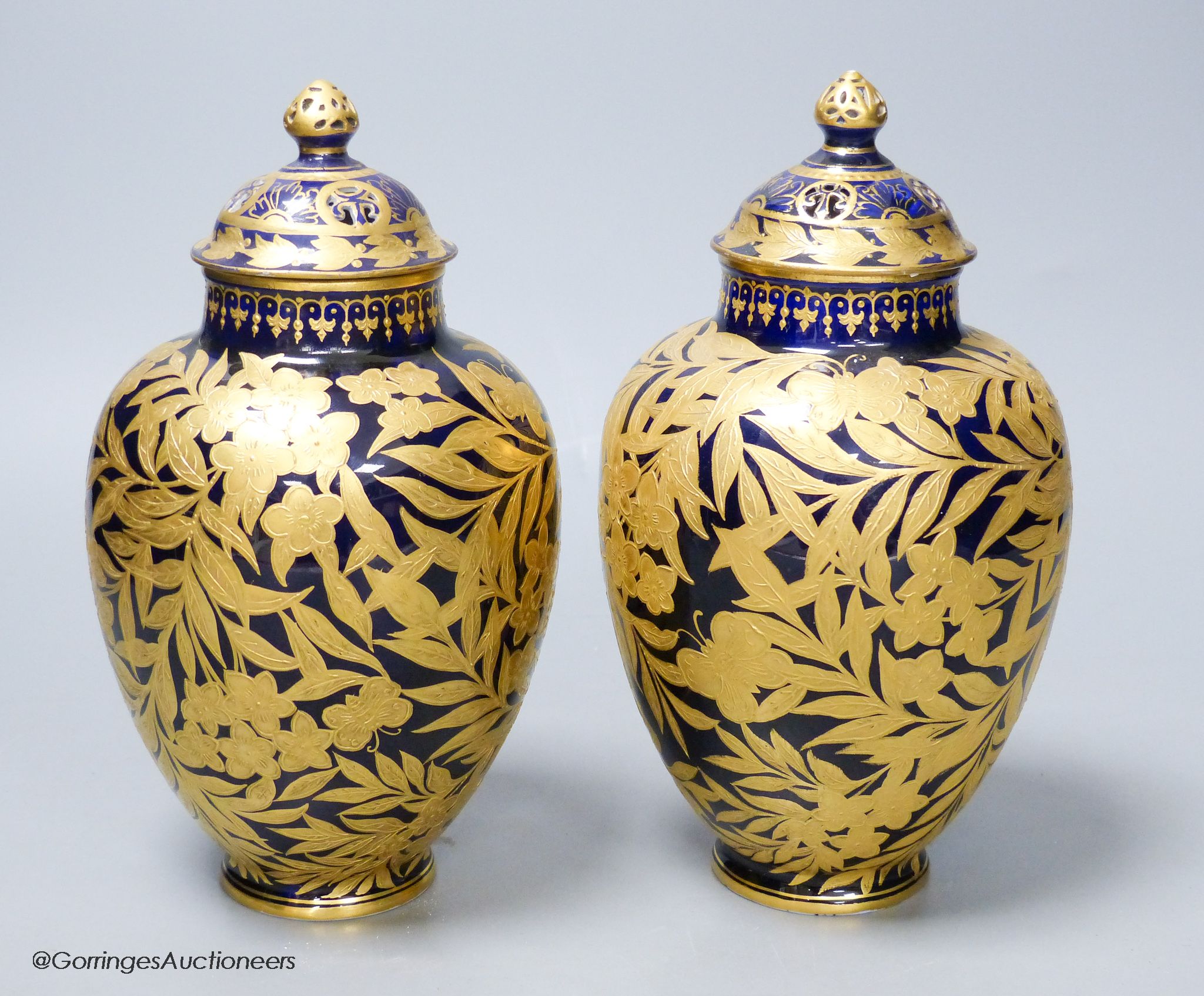 A pair of Crown Derby blue and gilt vases, both with restored lids, height 21cm